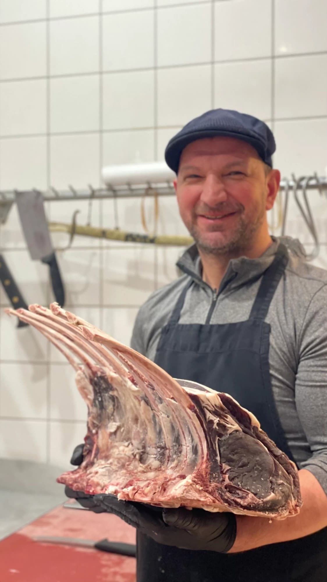 De slager met een stuk rib in zijn handen